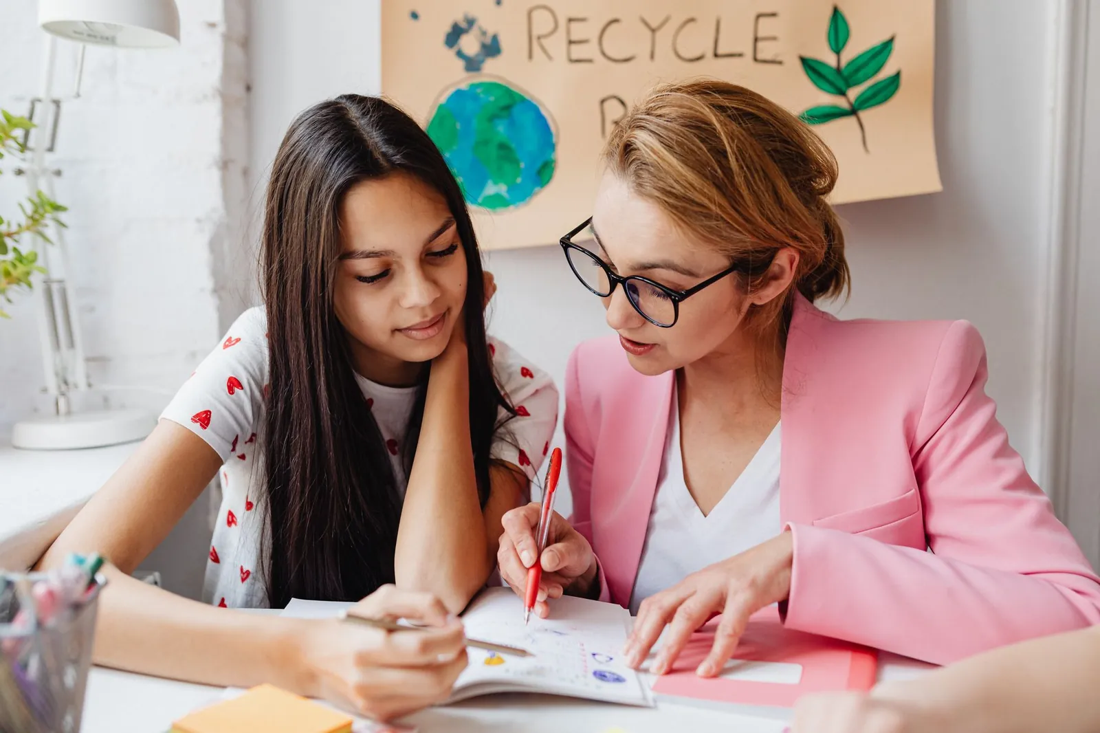 Enseignante qui accompagne une élève dans ses exercices